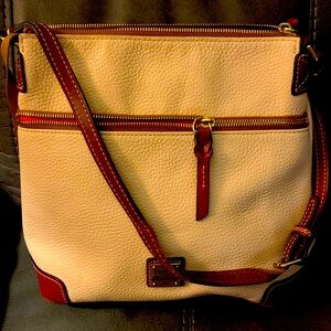 A beautiful Dooney and Bourke Tan pocketbook with strap and hook for keys.